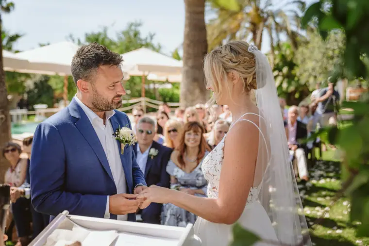 Iain placing the ring on Sophie's finger in the garden ceremony at Can Gall