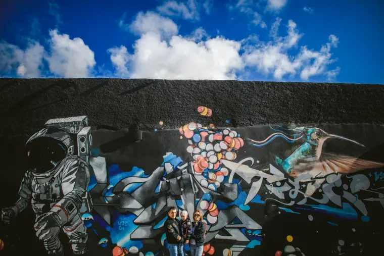 Colourful graffiti mural of an astronaut beneath a bright blue sky