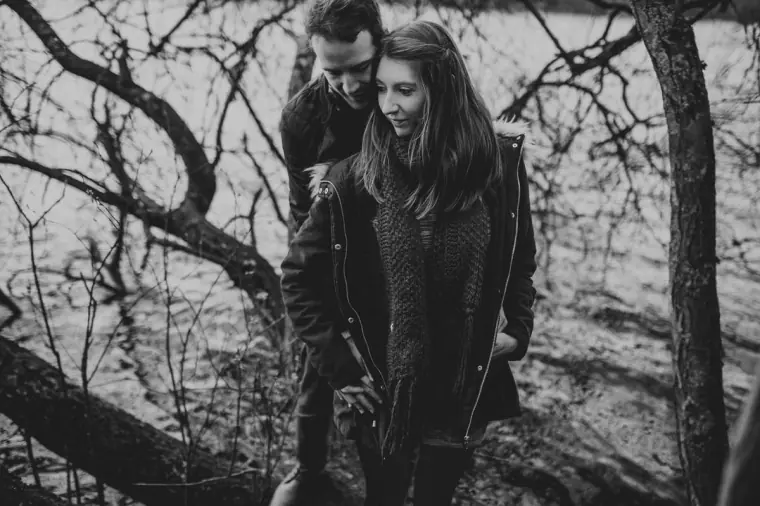 Black-and-white photo of the couple among gnarled tree branches