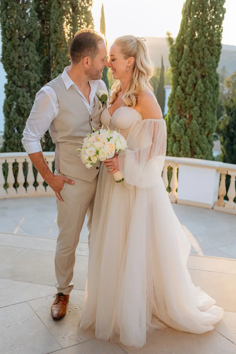 Jade and Peter facing each other on the balustraded terrace at Anassa Hotel