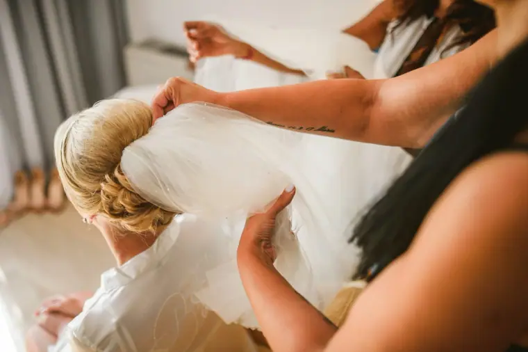 Bridesmaids helping Charlotte step into her wedding dress