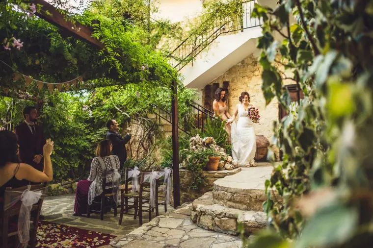 Bride walking down the stone steps into the leafy courtyard at Vasilias Nikoklis Inn