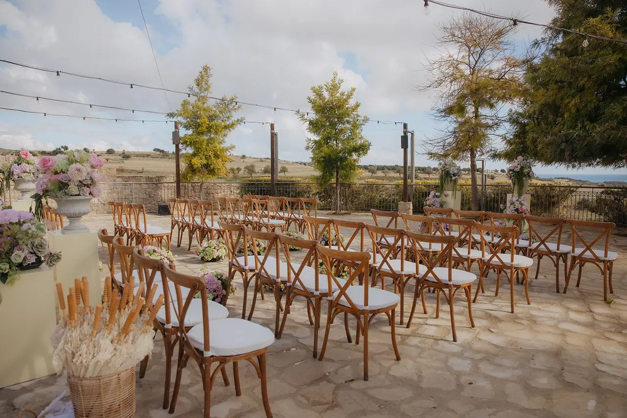 Rows of wooden chairs and dried wheat baskets on the ceremony terrace at Liopetro