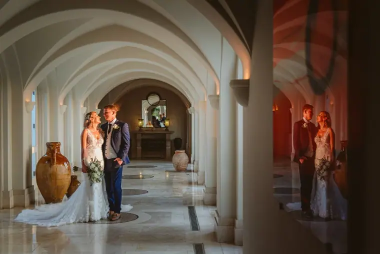 Carly and Jack standing together in the vaulted corridor at Anassa Hotel