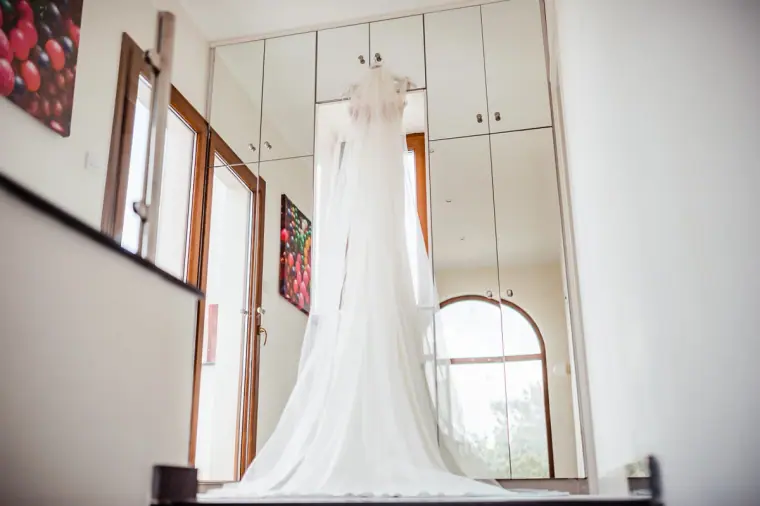 Wedding dress hanging high in a bright double-height villa room