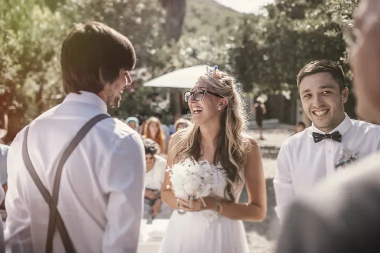 Bride laughing as she reaches the groom at the start of the ceremony