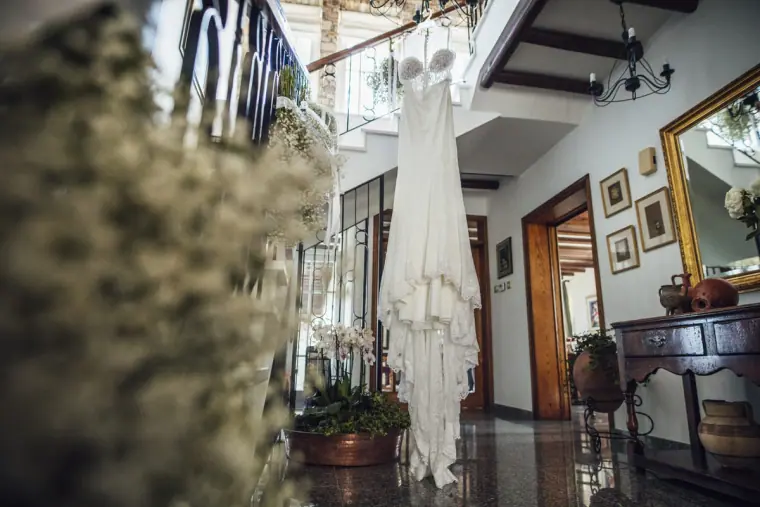 Ruby's lace wedding dress hanging in the hallway, framed by gypsophila