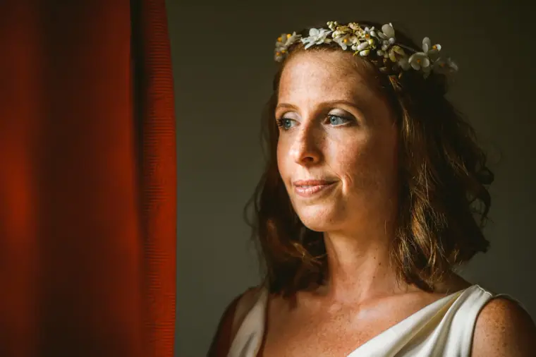 Close portrait of the bride in a flower crown gazing towards the window