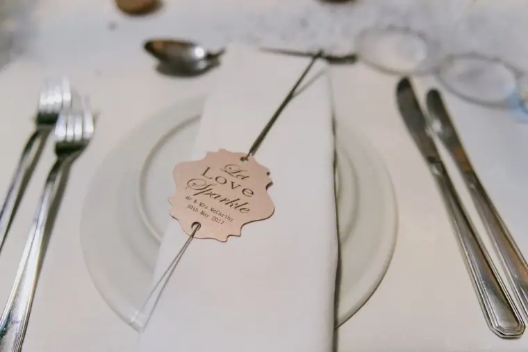 Place setting with a wooden Love Sparkles favour tag and silver cutlery