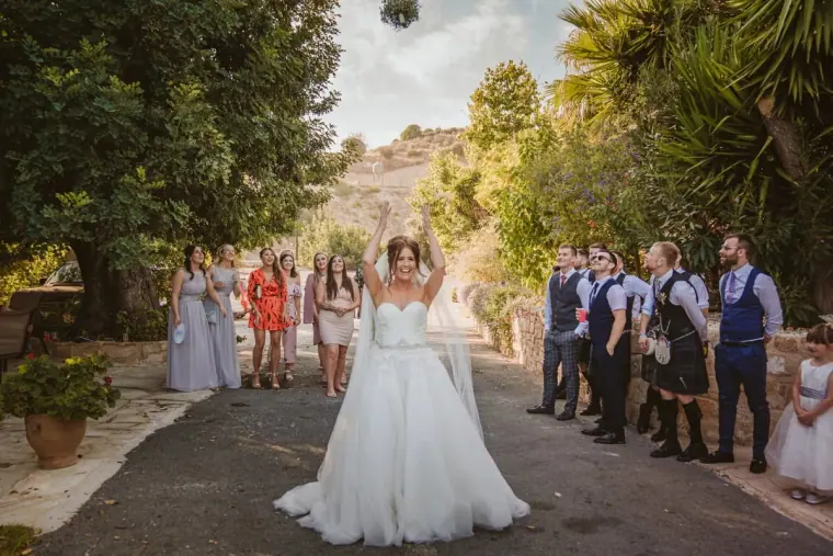 Hannah tossing her bouquet over her shoulder towards waiting guests