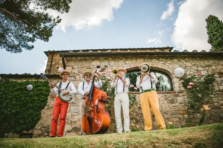 Swing band with double bass, banjo and brass playing on the lawn outside the stone villa