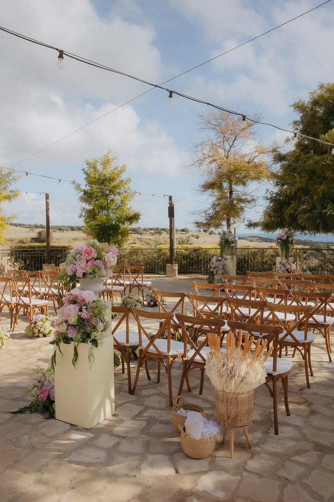 Ceremony chairs and flowers on the terrace with the Paphos countryside behind