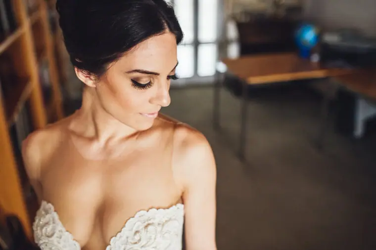 Ruby looking down in her strapless lace gown, softly lit