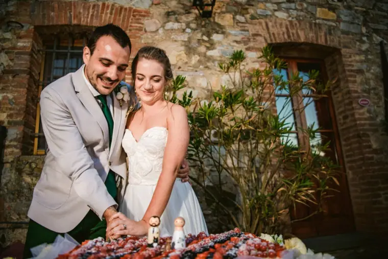 Bride and groom smiling as they cut a dessert at the reception