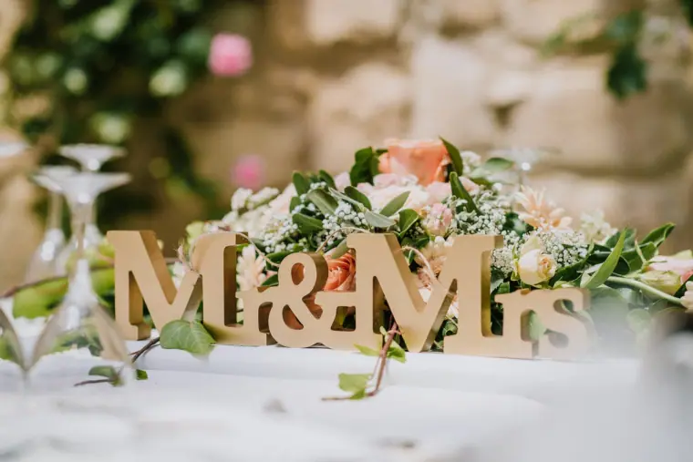 Wooden Mr & Mrs letters on the top table surrounded by flowers