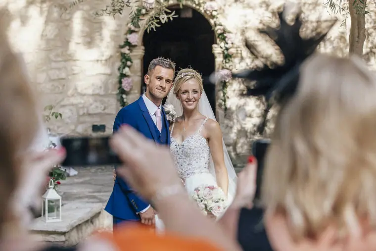 Guests photographing the smiling couple on their phones