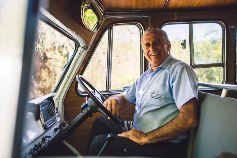 Smiling driver at the wheel of the vintage Bedford bus