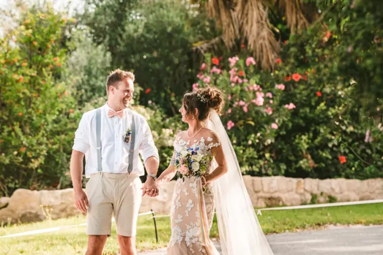 Newlyweds strolling hand in hand through the gardens at Vasilias Nikoklis Inn