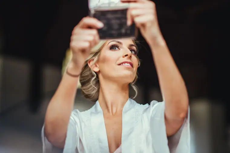 Leonnie holding up a compact mirror to check her make-up