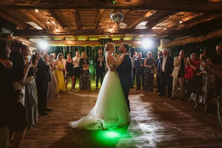 Sophie and Iain's first dance in a timber-beamed room as guests watch