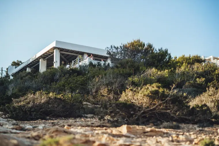 White villa perched above rocky scrubland on the Ibiza coast