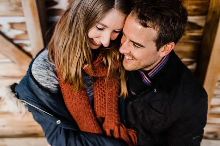 Jana and Alex laughing in a hug inside a wooden play structure