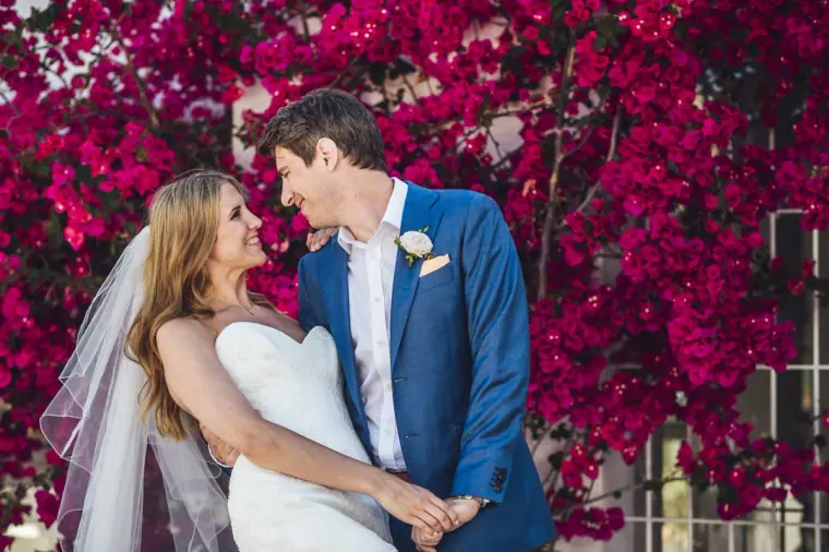 Stephanie and Paul dancing in front of a wall of magenta bougainvillea