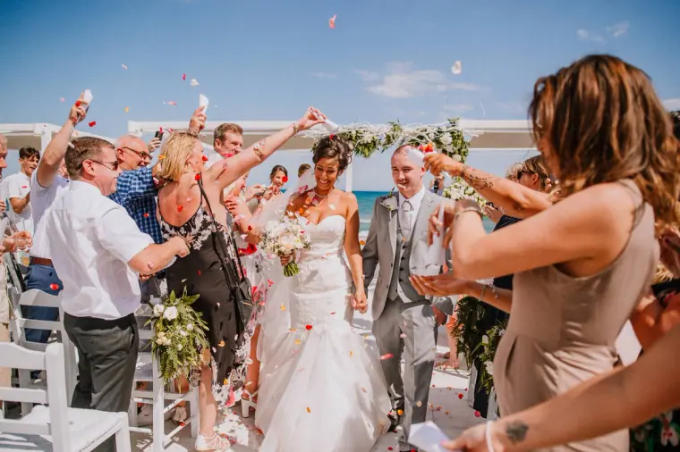 Guests throwing petals as Louise and Mike walk back up the aisle