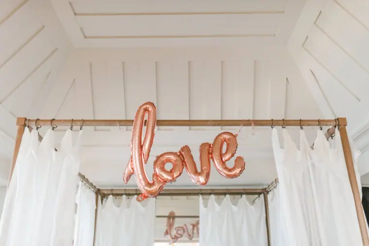 Rose-gold "love" balloon hanging in a white-draped room at Anassa, Cyprus
