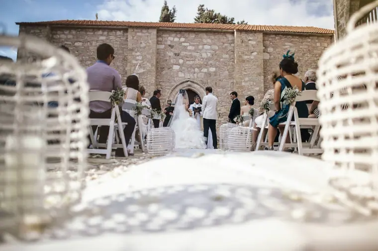 Ceremony in the stone monastery courtyard framed by white wicker lanterns, Minthis Hills