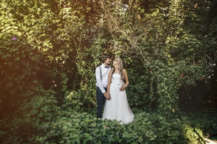 Bride and groom standing together in a leafy green garden at Hidden Bar, Ibiza