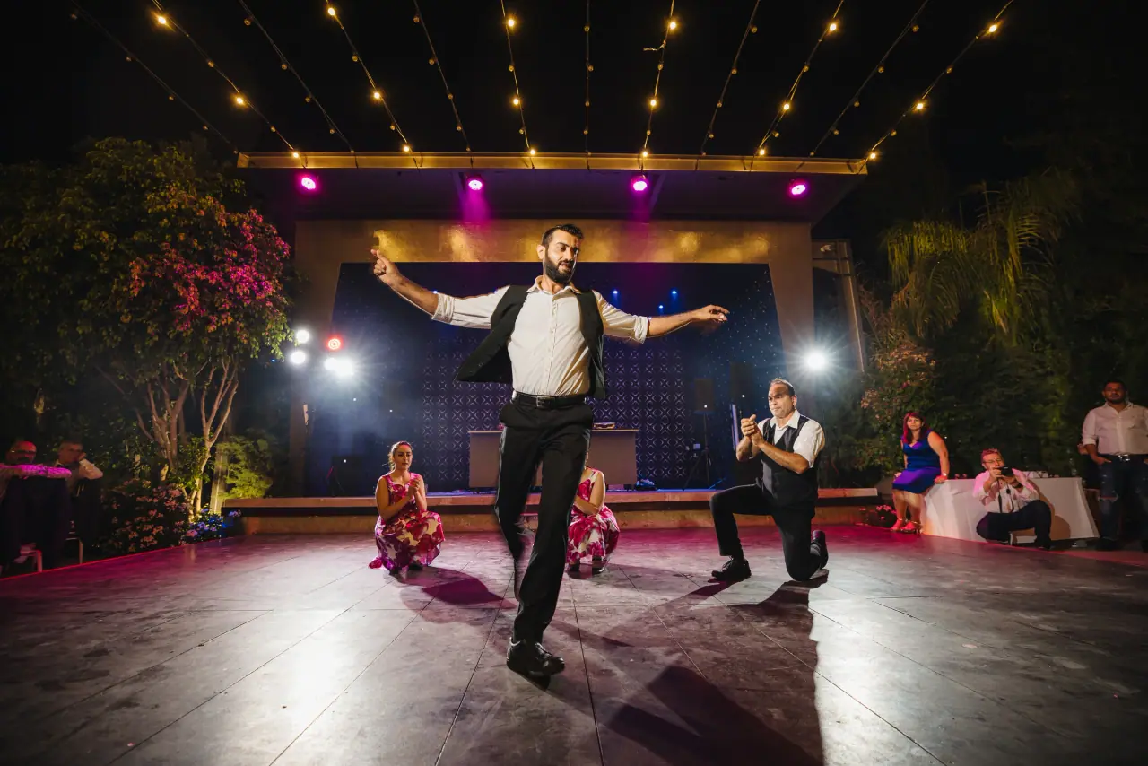 Groom dancing in the spotlight on a stage-lit dancefloor