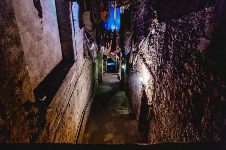 Dark narrow close lit by a single blue light, Edinburgh Old Town
