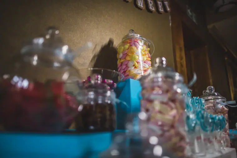 Sweet table with glass jars of colourful sweets on a turquoise cloth