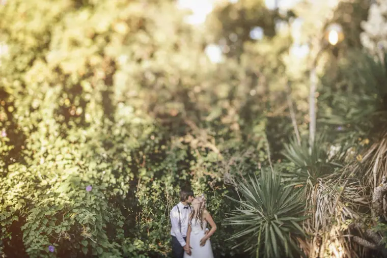 Couple small among palms and dense greenery in the garden
