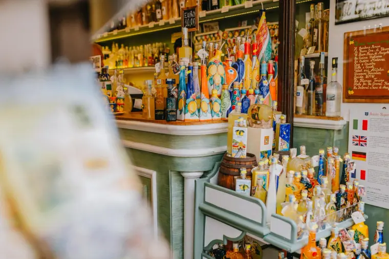 Shop shelves packed with colourful bottles of limoncello and liqueurs in Sorrento