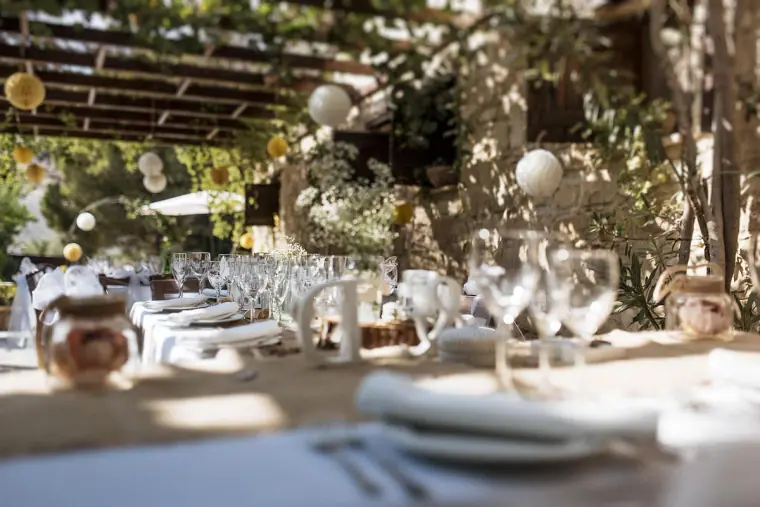 Long reception tables with glassware and paper lanterns under the pergola