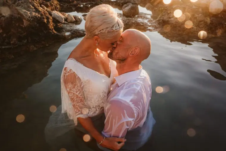 Alana and Luke kissing waist-deep in a glowing rock pool near Paphos
