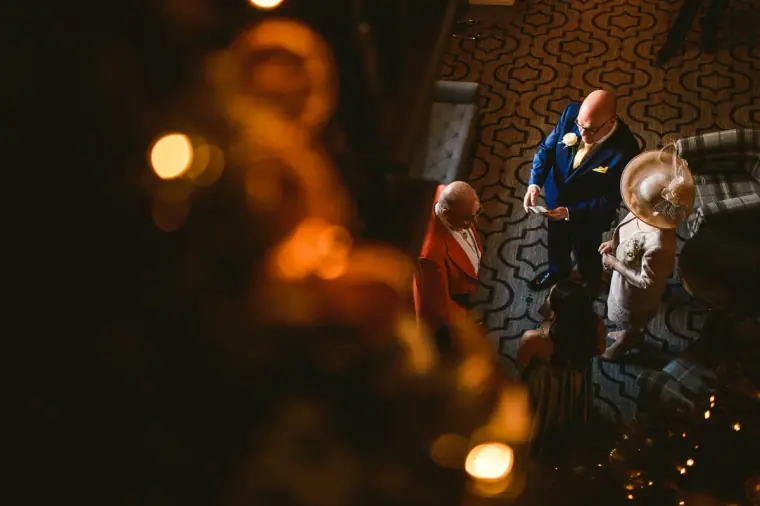 Groomsmen and a toastmaster seen from above through warm golden bokeh