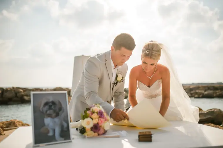 Charlotte and Nathan signing the register beside a framed photo of a dog