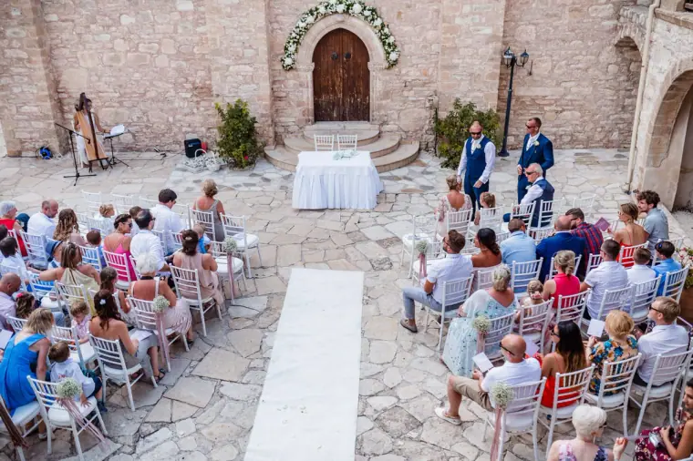 Guests seated in the monastery courtyard awaiting the bride at Minthis Hills