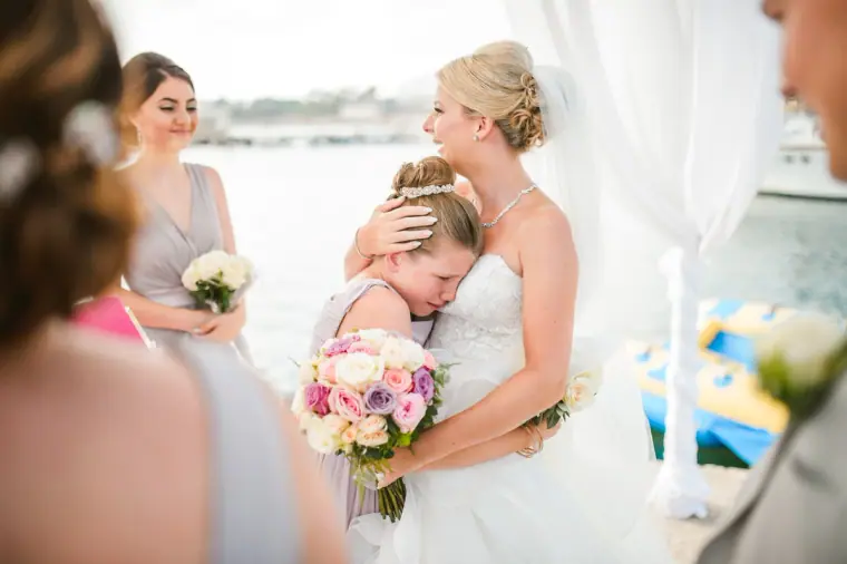 Charlotte hugging a young bridesmaid after the ceremony