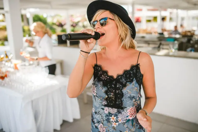 Singer in a black hat and sunglasses performing at the drinks reception