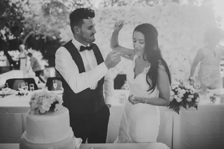 Black-and-white photo of Jaclyn and Steven cutting their wedding cake
