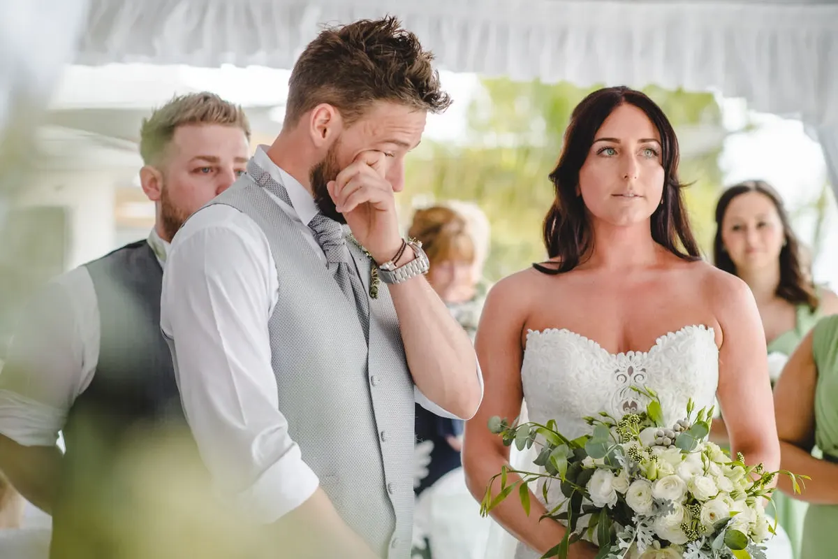 Groom wiping away a tear as his bride arrives at the ceremony
