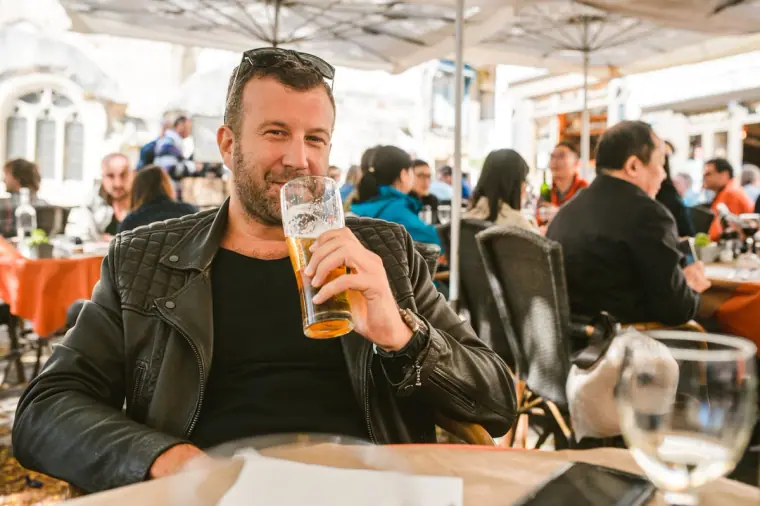 Guest drinking a pint of beer at a busy pavement café in Bordeaux
