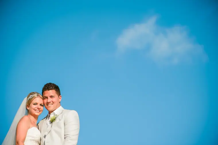 Charlotte and Nathan smiling cheek to cheek against a clear blue sky