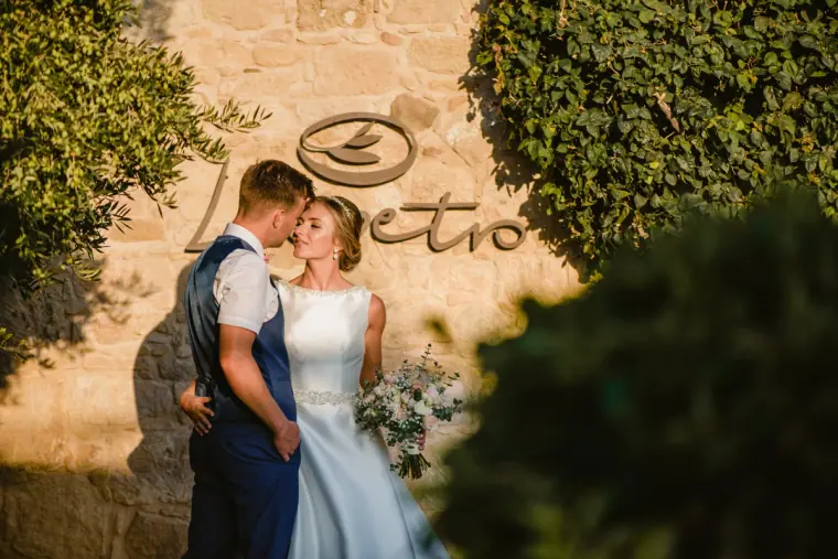 Couple kissing beside the Liopetro sign on a stone wall at Liopetro, Kouklia