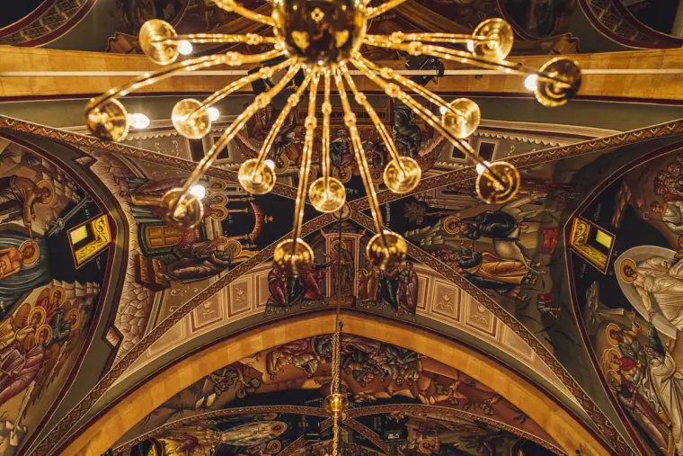 Gilded chandelier and painted frescoes on the church ceiling