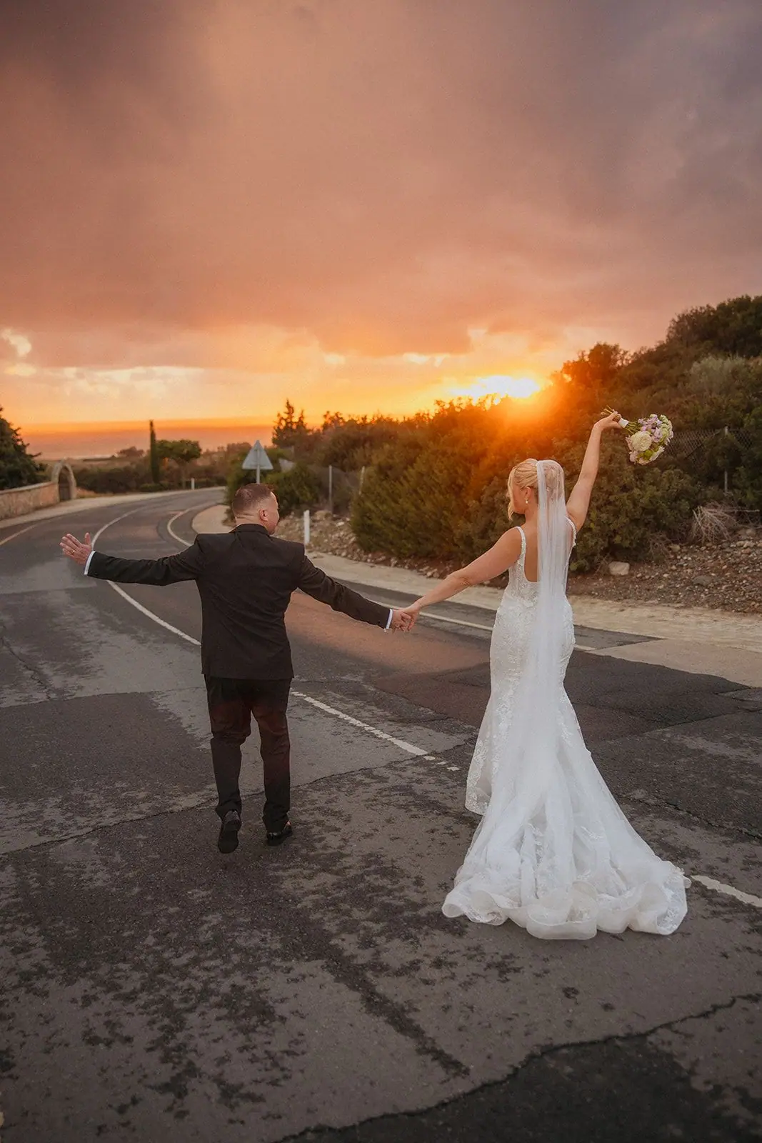Zoe and Oliver dancing hand in hand down the road towards the setting sun